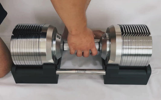 Adjustable dumbbell being used, ideal gym equipment for versatile workouts with dumbbells, kettlebells, and resistance bands.