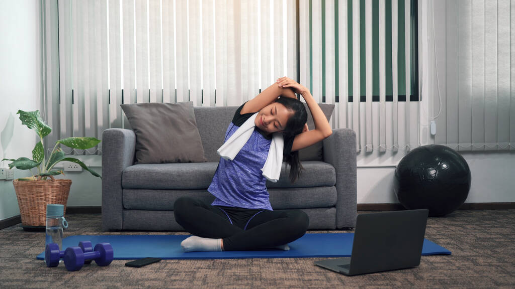 asian woman stretching yoga class trainer her laptop computer home