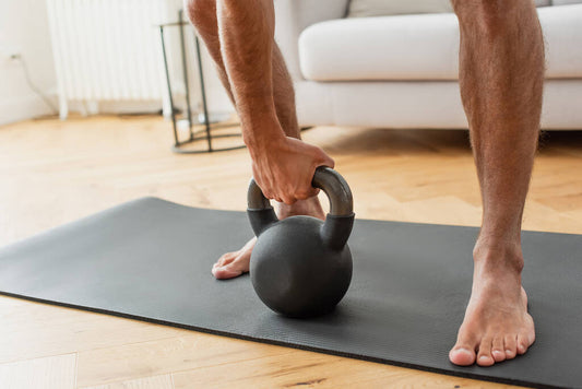 barefoot sportsman exercising kettlebell home