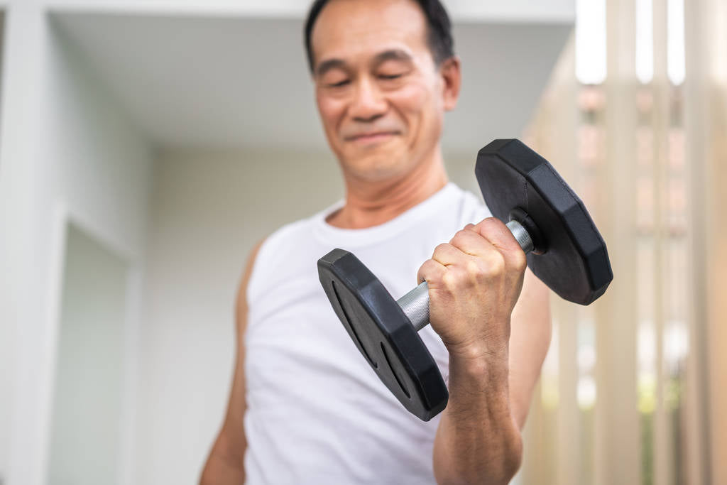 senior man lifting dumbbell in fitness gym