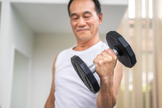senior man lifting dumbbell in fitness gym